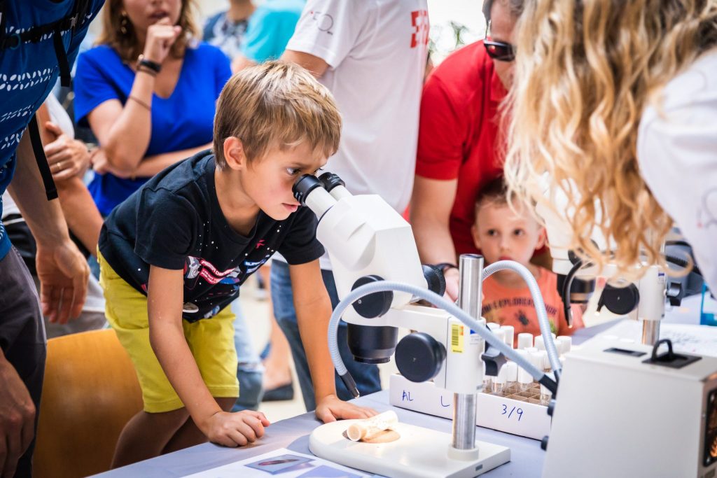 Enfants regardant dans un microscope durant les portes ouvertes 2019 © Jamani Caillet, EPFL, 2019