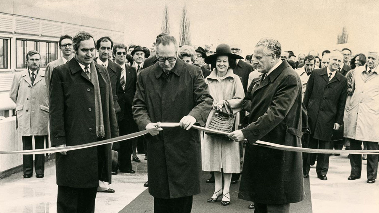 Hans Hürlimann, conseiller fédéral, coupe un ruban d'inauguration et est entouré de Maurice Cosandey, président de l'EPFL et Huber, directeur des constructions fédérales.