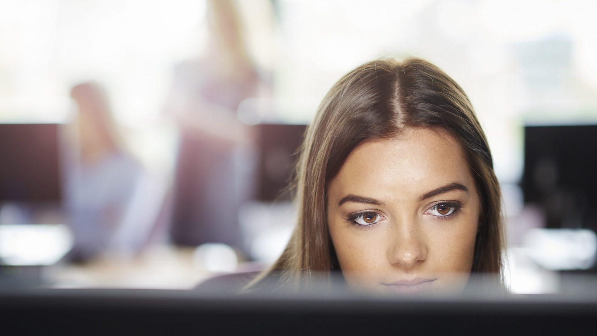 Une femme deriière un écran d'ordinateur