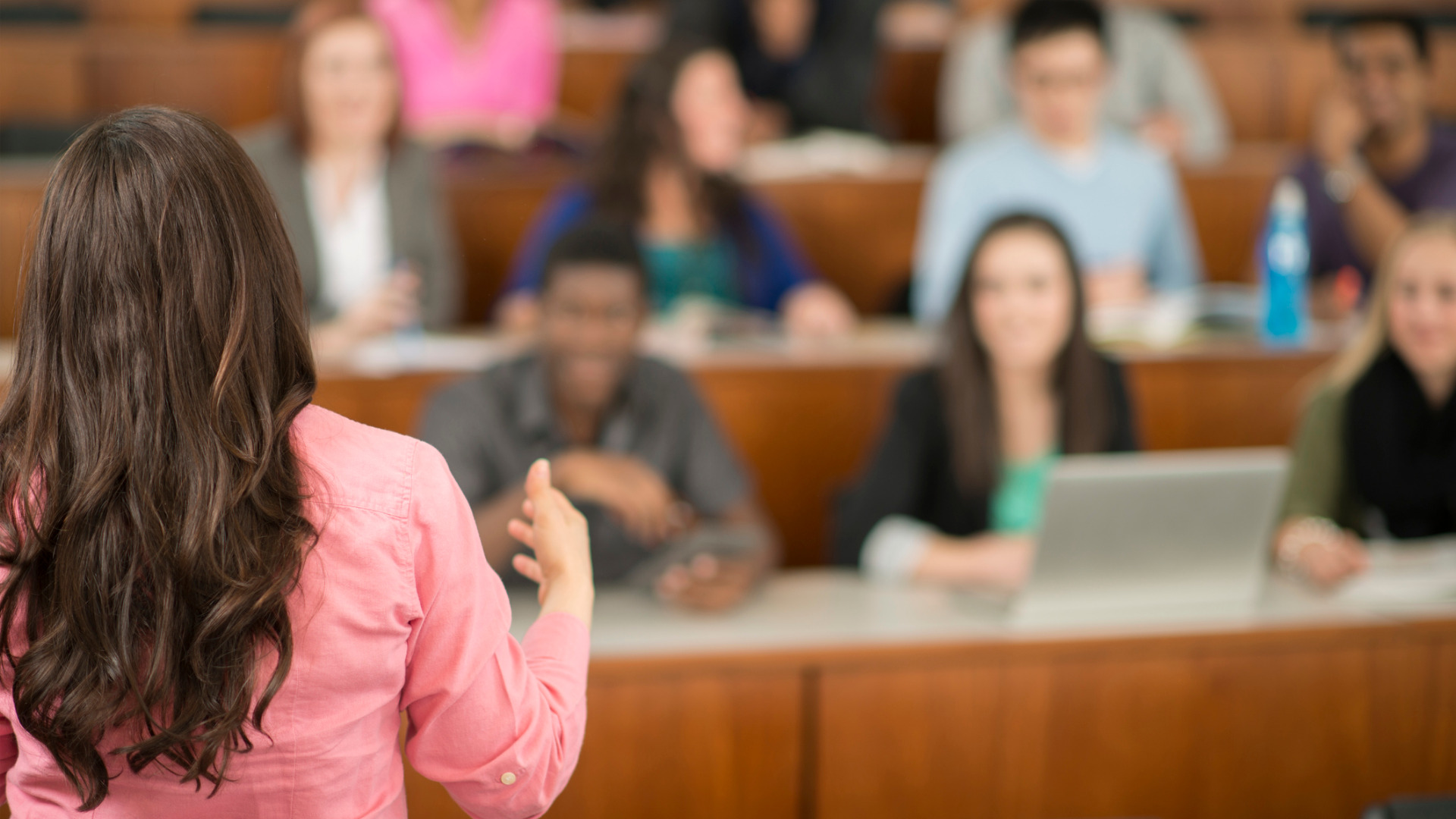 Une enseignante, de dos, donnant un cours