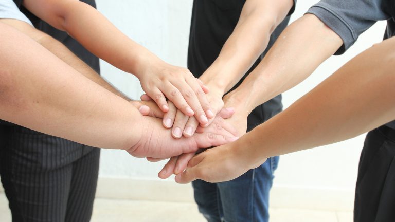 Plusieurs mains les unes sur les autres, illustrant le soutien individuel © Shutterstock