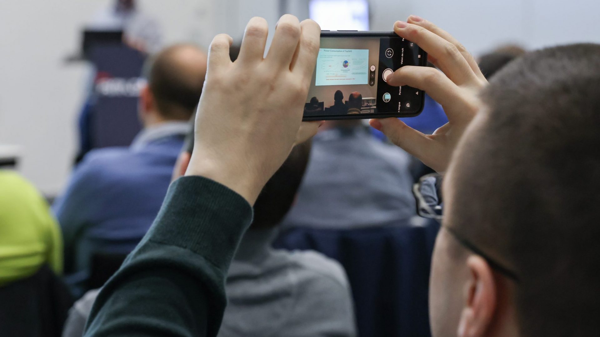 Une personne faisant une photo d'une conférence avec son téléphone portable - CC-BY-SA Alain Herzog, EPFL 2024