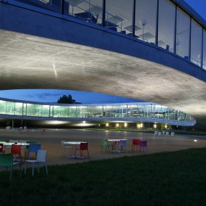 La cour intérieure du Rolex Learning Center, de nuit. Des chaises au premier plan