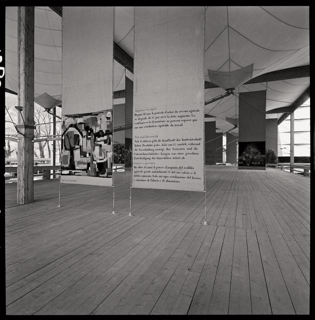 Exposition nationale suisse de 1964. Vue intérieure du pavillon du secteur Terre et forêt (architecte : Jakob Zweifel). Le plancher, les colonnes et les poutres sont en bois. Entre les poutres sont tendues des membranes en voile de coton.