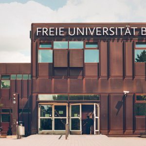Façade du bâtiment principal de la Freie Universität de Berlin recouverte de panneaux métalliques à l’aspect rouillés, arrondis aux angles.