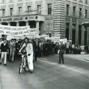 Des étudiant·e·s manifestent avec des banderoles, pour une restructuration des organes universitaires, dans les rues de Lausanne.