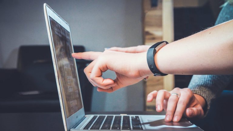 person pointing at a computer screen