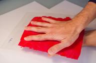 illustration - hand is used to warm up glazing with red thermochromic coating