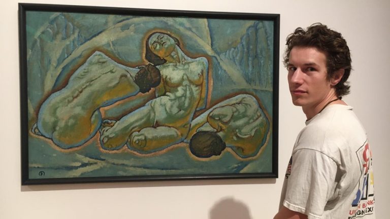 Alexander Rusnak standing in front of a painting